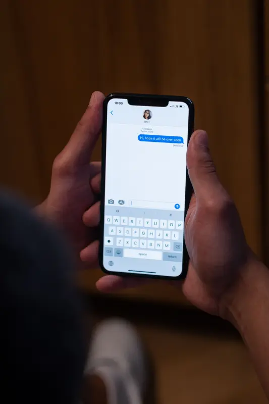 Hands holding a phone with a message thread open