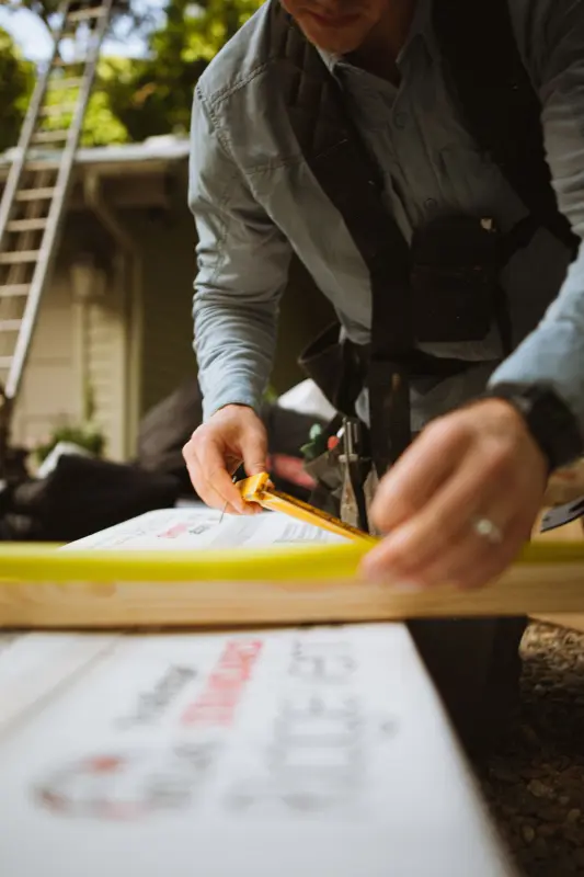 A tradesperson marking a measurement on timber